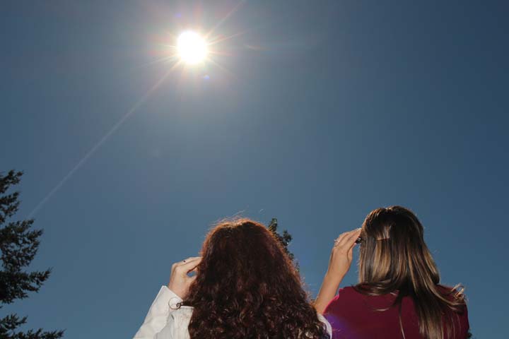 Two people view the solar eclipse.