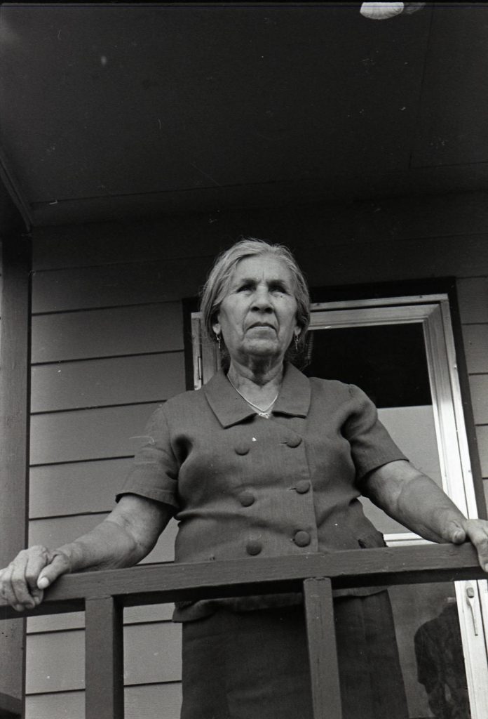 Martina Molina Gamboa standing on a porch. Sunnyside, Wash. 1971.