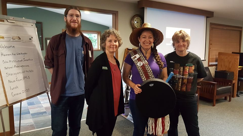 Enrolled tribal member Loni Greninger (second from right) opened the annual Washington State Tribal Librarians meeting in August 2019 with a welcome song. The Heron Library on the Jamestown S’Klallam Reservation hosted the meeting. Pictured with Greninger are (from left) library staff members Brandon Taft, Bonnie Roos, and Jan Jacobson. (Photo: Washington State Library)