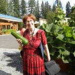 Carolyn Petersen holding a zucchini from the Hibulb Cultural Center