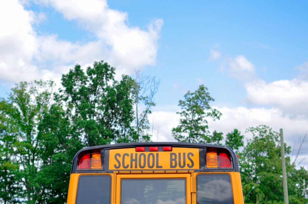 Picture of a school bus and a blue sky with clouds