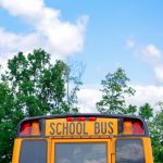Picture of a school bus and a blue sky with clouds